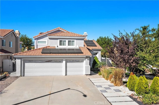 20664 Brana Rd, Riverside, CA 92508 - view of front of house featuring stucco siding, a tile roof, roof mounted solar panels, driveway, and a garage