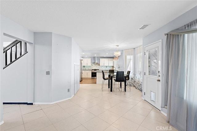 interior space with an inviting chandelier, light tile patterned flooring, and a textured ceiling