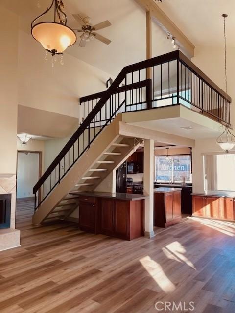 interior space featuring ceiling fan, wood-type flooring, and high vaulted ceiling