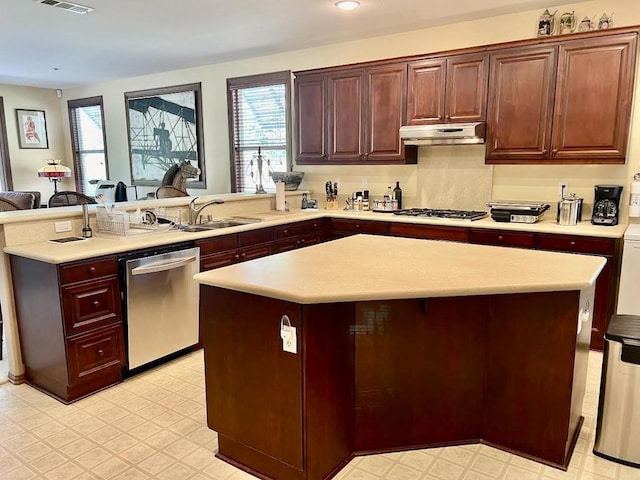 kitchen with stainless steel appliances, a center island, sink, and kitchen peninsula