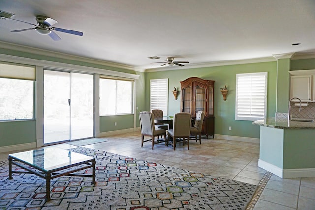 dining area featuring crown molding, sink, and ceiling fan