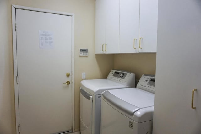 laundry area with washer and dryer and cabinets