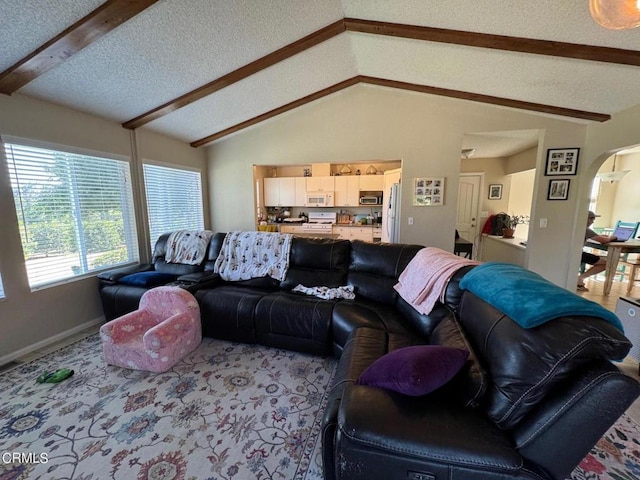 living room featuring carpet, lofted ceiling with beams, and a textured ceiling