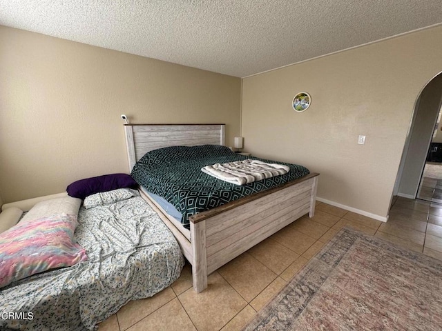 bedroom with tile patterned floors and a textured ceiling