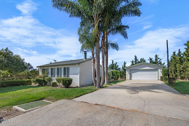 view of front of home with a front yard, an outbuilding, and a garage