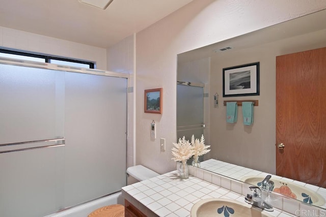 bathroom featuring toilet, vanity, and walk in shower