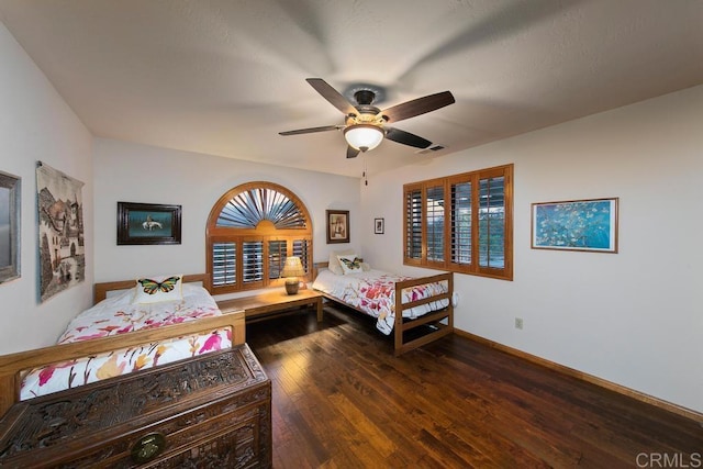 bedroom with ceiling fan and dark wood-type flooring