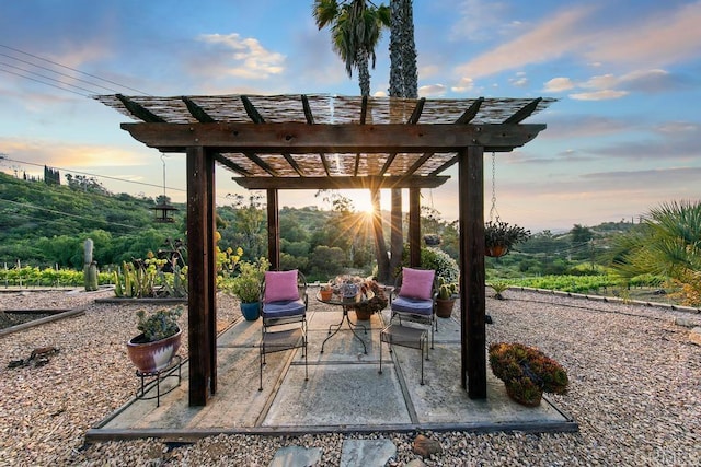 patio terrace at dusk with a fire pit and a pergola