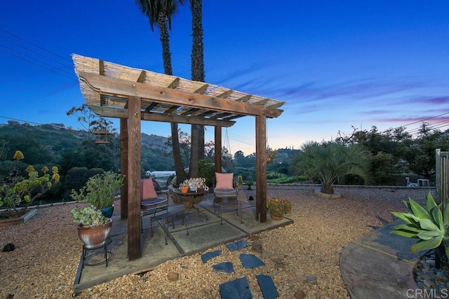 yard at dusk with a patio area and a pergola