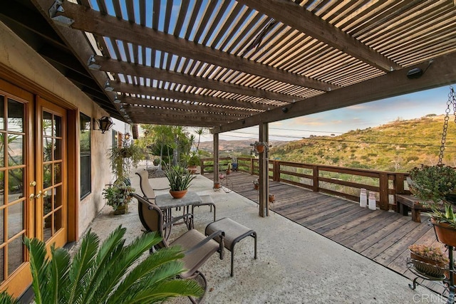 view of patio with a pergola, a mountain view, and french doors