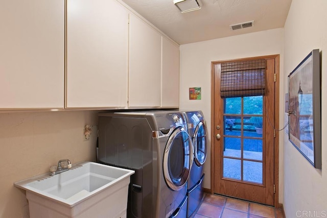 laundry room featuring independent washer and dryer, sink, light tile patterned floors, and cabinets