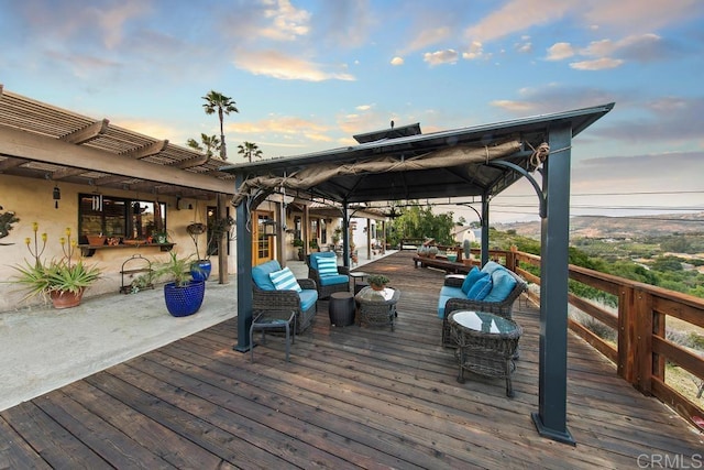 deck at dusk with an outdoor hangout area and a gazebo