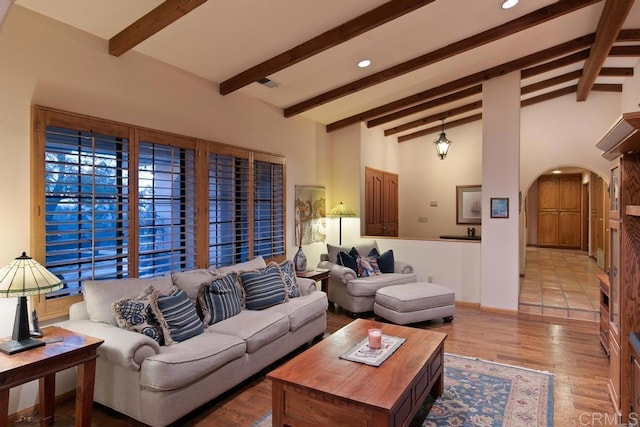 living room with lofted ceiling with beams and light hardwood / wood-style floors