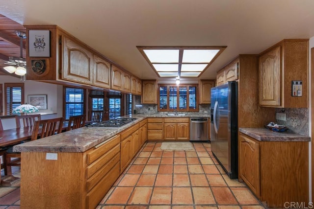 12622 Sierra Rojo, Valley Center, CA 92082 - kitchen with appliances with stainless steel finishes, a sink, tasteful backsplash, ceiling fan, and a peninsula