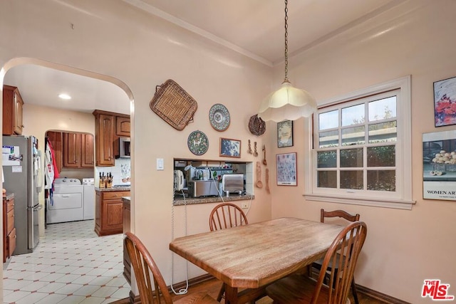 dining area featuring washer and clothes dryer and ornamental molding