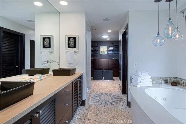 bathroom with tiled bath and vanity