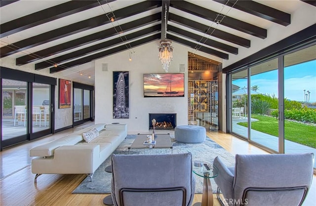 living room featuring light hardwood / wood-style flooring, a notable chandelier, and vaulted ceiling with beams