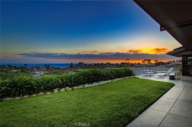 yard at dusk featuring a patio area