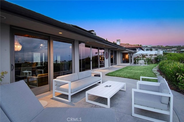 patio terrace at dusk with a lawn and outdoor lounge area