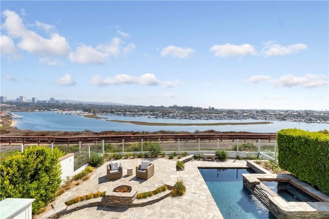 view of pool featuring a patio area, an in ground hot tub, a water view, and a fire pit