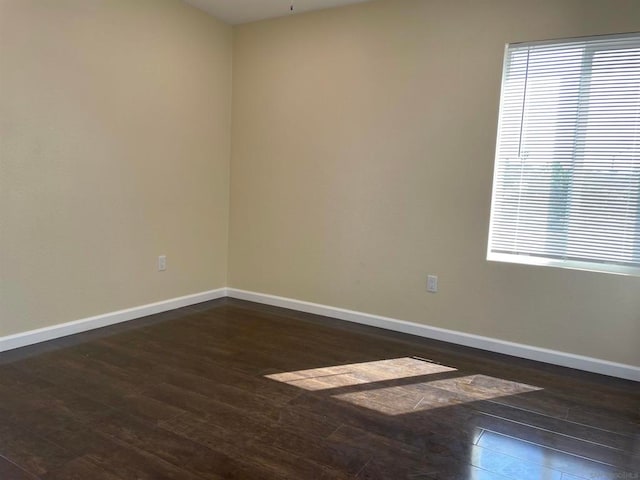 spare room featuring dark wood-type flooring and ceiling fan