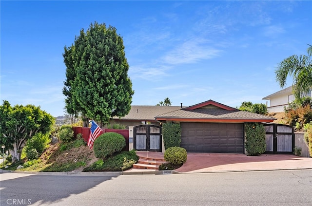 view of front of property featuring an attached garage and decorative driveway