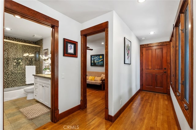 hall with recessed lighting, wood finished floors, and baseboards