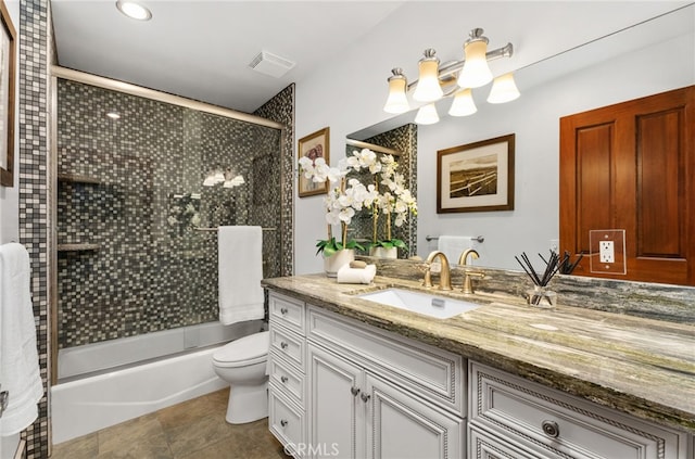 full bathroom featuring toilet, bath / shower combo with glass door, vanity, visible vents, and tile patterned floors