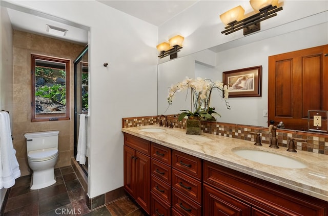 bathroom featuring visible vents, a sink, toilet, and double vanity