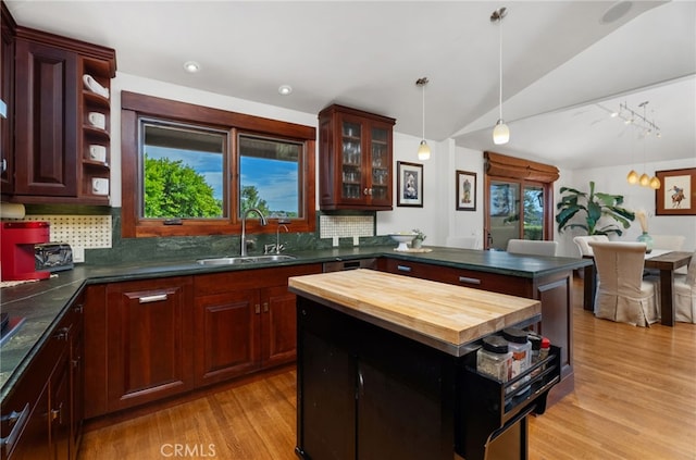 kitchen featuring plenty of natural light, tasteful backsplash, light wood-style flooring, wood counters, and a sink