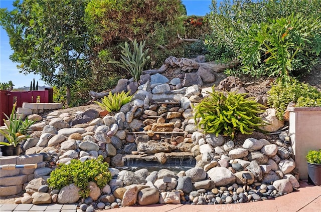 view of yard featuring fence and a small pond