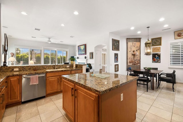 kitchen with stainless steel dishwasher, ceiling fan, sink, pendant lighting, and a center island