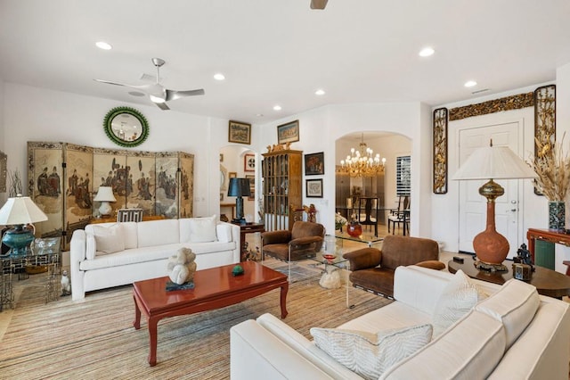 living room featuring ceiling fan with notable chandelier