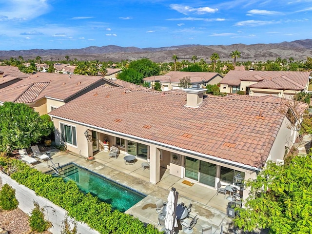 rear view of house with a mountain view and a patio