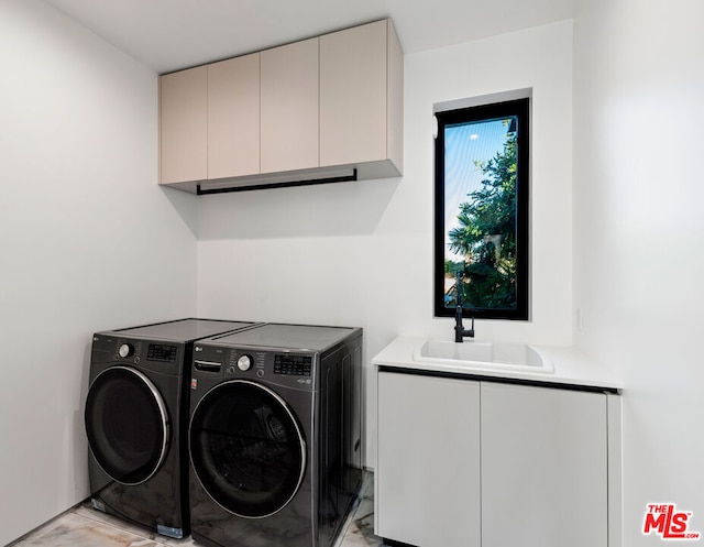 washroom featuring cabinets, sink, and washing machine and dryer