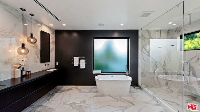 bathroom with separate shower and tub, vanity, and tile walls