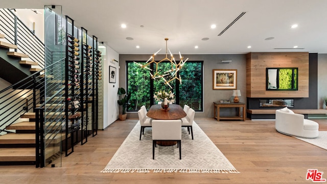 dining area with an inviting chandelier and light hardwood / wood-style flooring