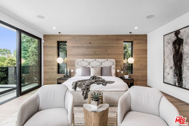 bedroom featuring access to outside, hardwood / wood-style flooring, and wood walls