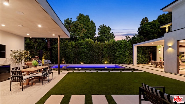 yard at dusk featuring a patio