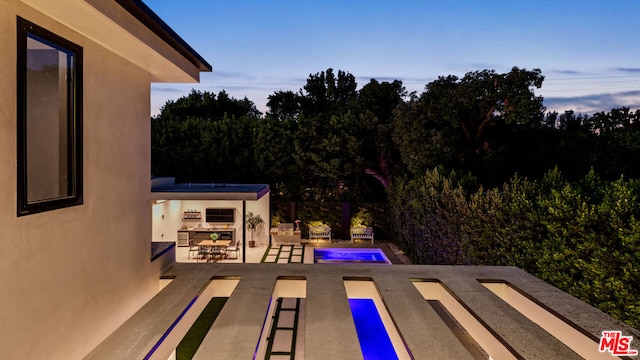 pool at dusk with a bar and a patio