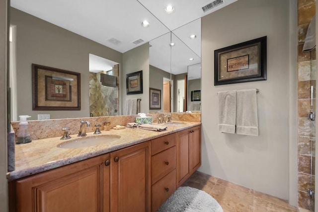 bathroom with a shower, vanity, and tile patterned floors