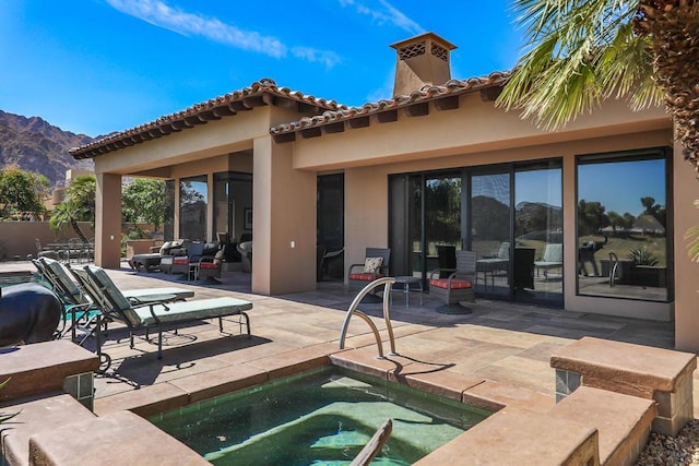 view of swimming pool with a mountain view, a patio, and a jacuzzi