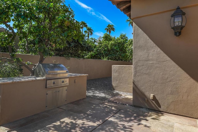 view of patio featuring an outdoor kitchen and a grill