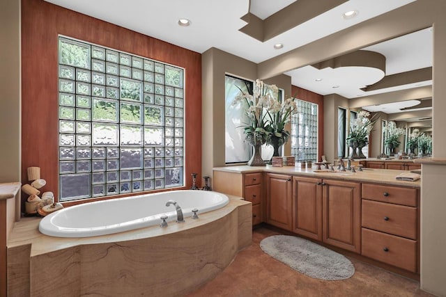 bathroom with vanity and a relaxing tiled tub