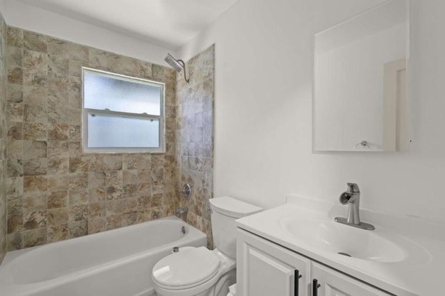 full bathroom featuring tiled shower / bath, vanity, and toilet