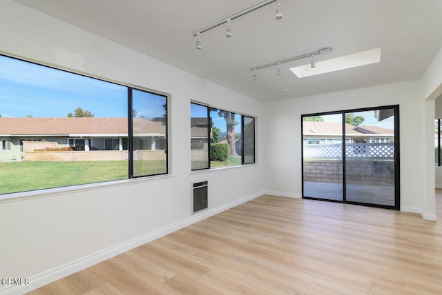 spare room with track lighting and light wood-type flooring