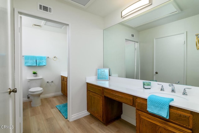 bathroom featuring wood-type flooring, vanity, and toilet