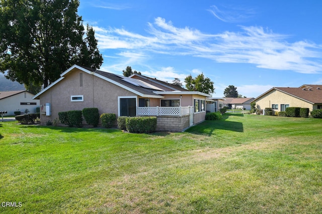 rear view of house featuring a lawn