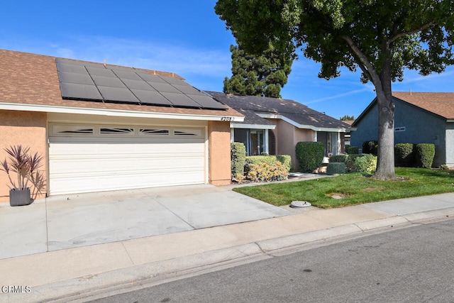 ranch-style home with a garage and solar panels