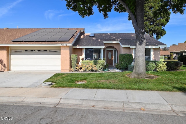 ranch-style home with solar panels, a front lawn, and a garage